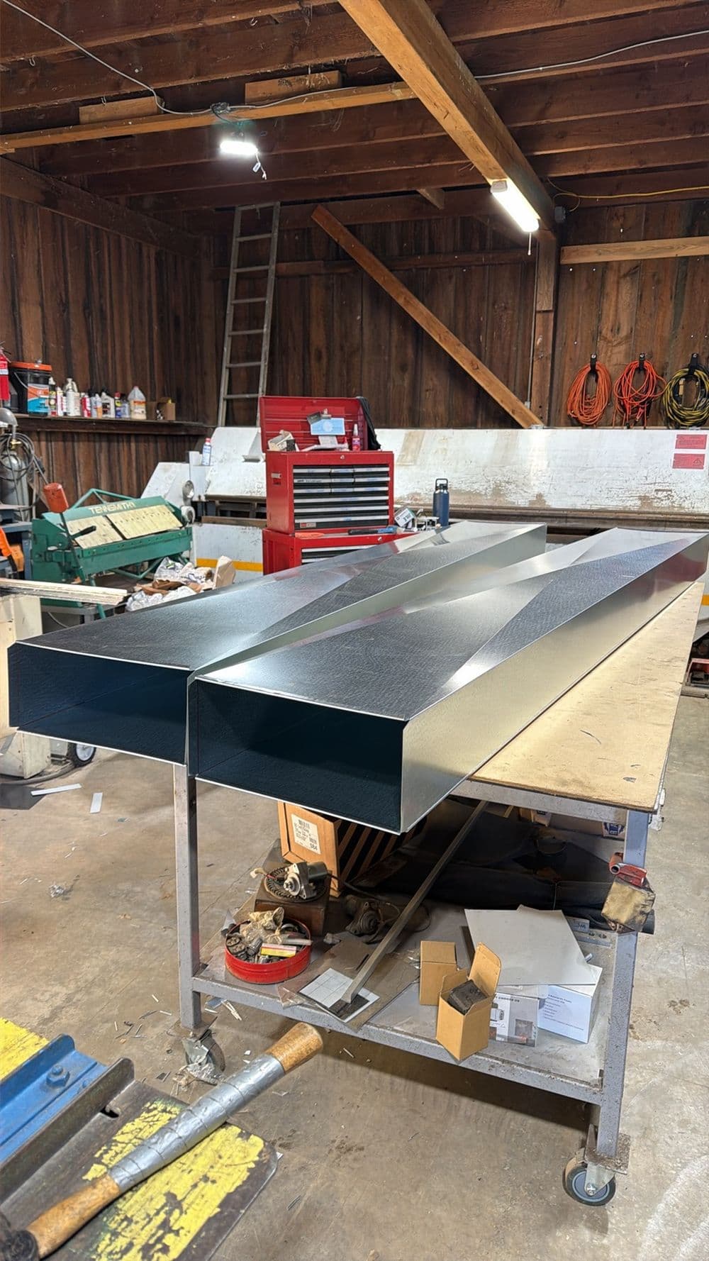 Metal fabrication project displayed on a workbench in a workshop with tools and equipment.