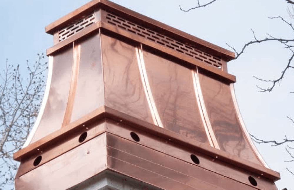 Copper chimney cap with decorative design, showcasing craftsmanship and durability.